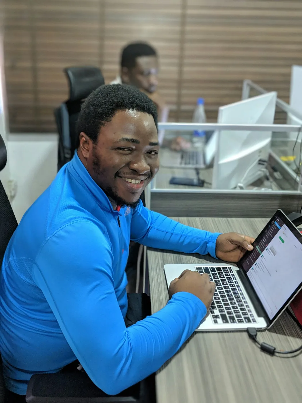 A smiling Fiber1Connect customer working on a laptop in a Lagos office